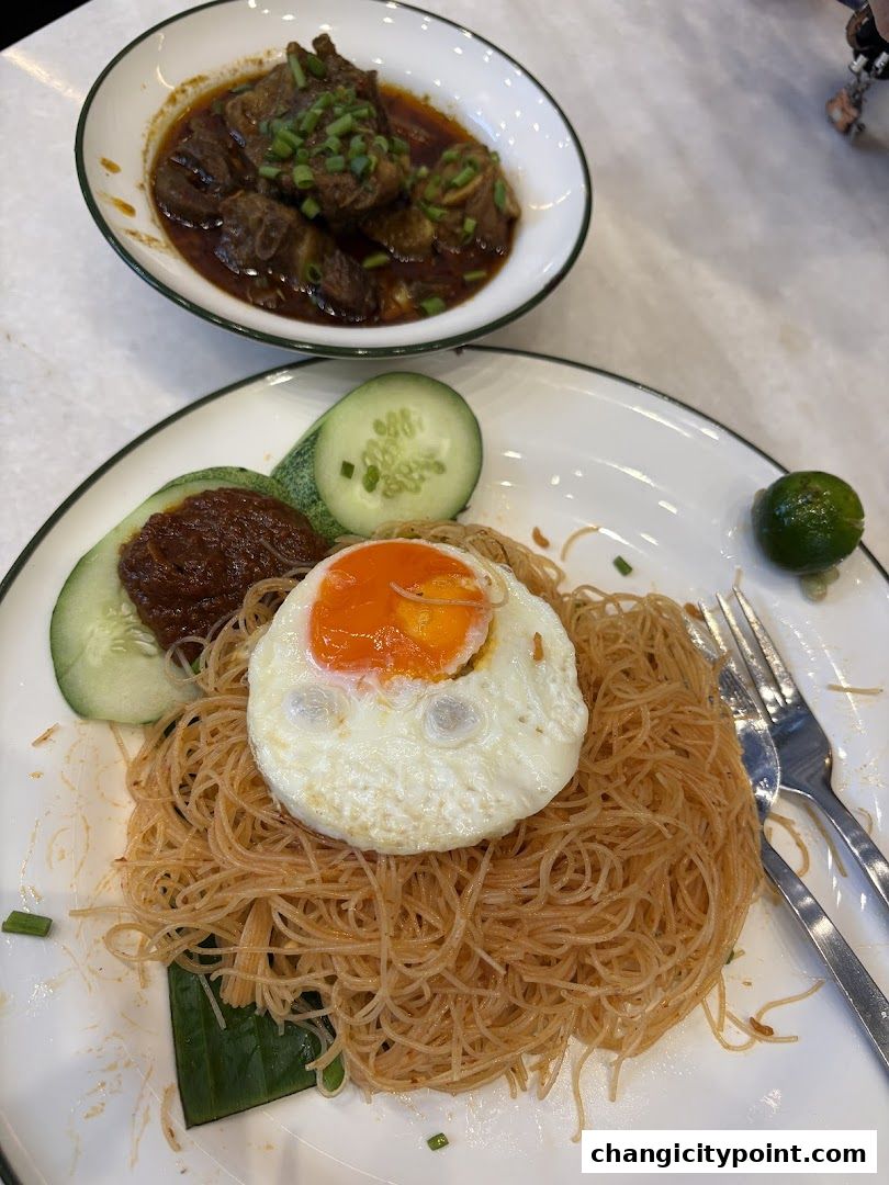A plate of bee hoon with a fried egg and a side of braised meat.