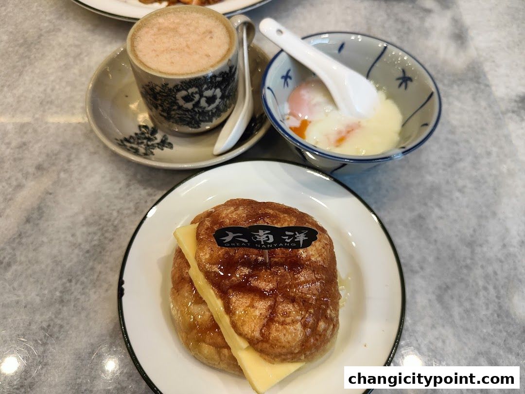 A close-up of a pastry with cheese, soft-boiled eggs, and a cup of coffee.