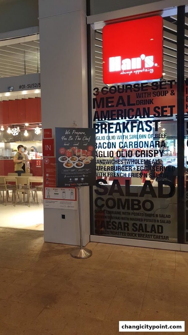 Exterior of Hans Cafe Changi City Point with menu items displayed on the window.