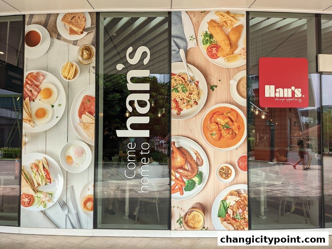 Exterior of Hans Cafe Changi City Point with appetizing food images on the glass.