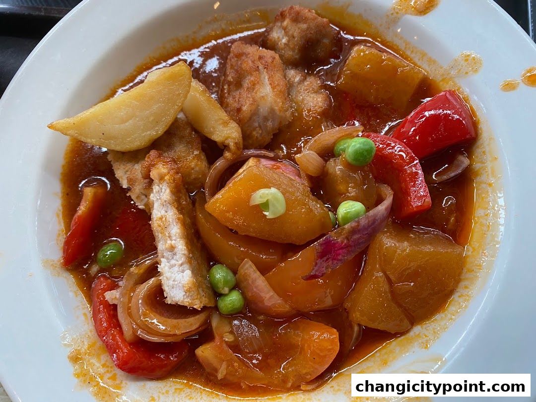 A close-up shot of a hearty stew with meat, potatoes, peppers, and peas.