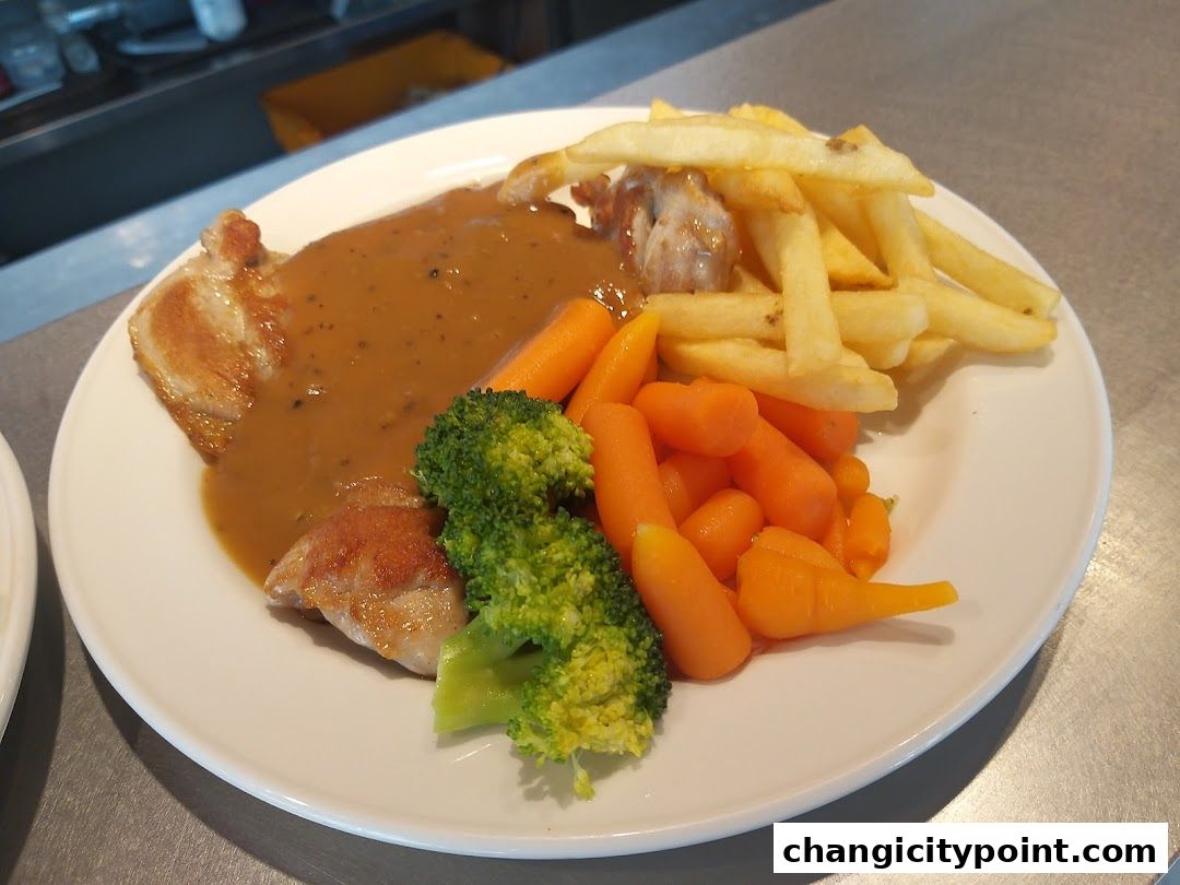 A plate of food with chicken, gravy, fries, carrots, and broccoli.