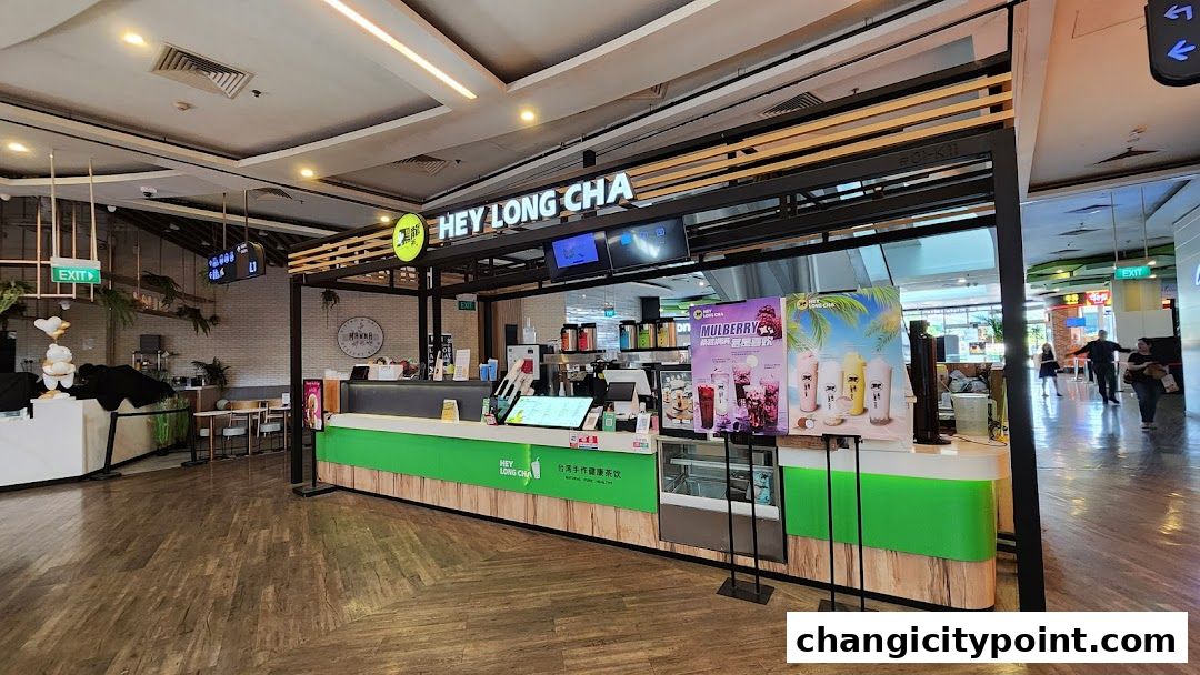 The exterior of a Hey Long Cha bubble tea shop with a bright green counter and promotional posters.