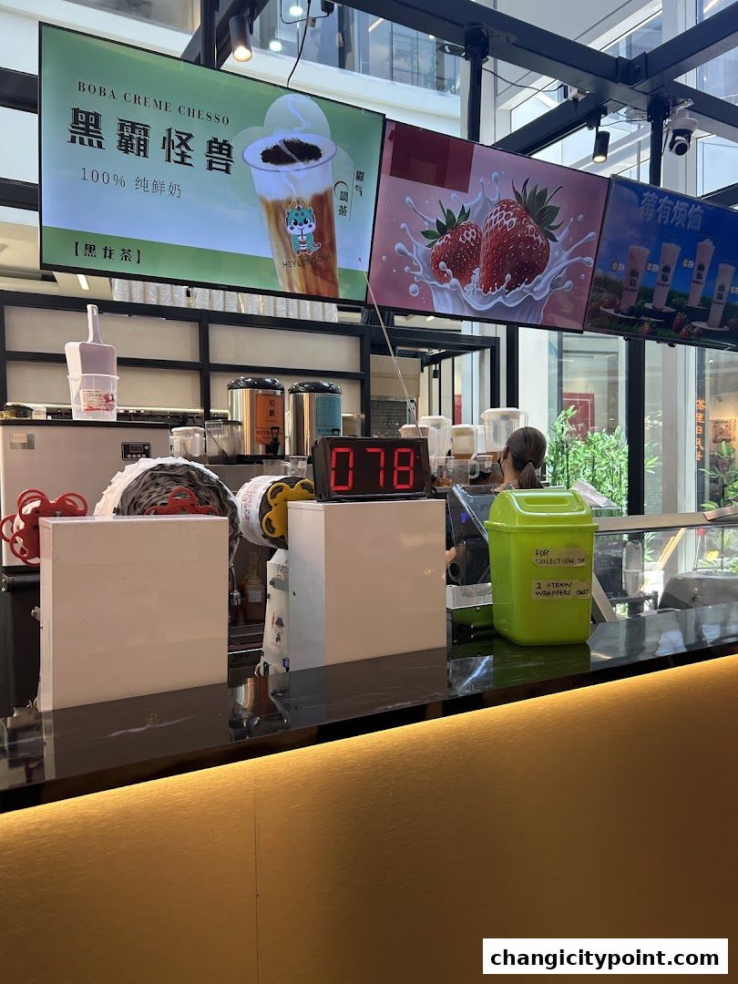 A counter at Hey Long Cha with digital displays showing boba tea and strawberries.