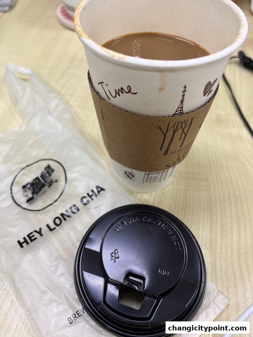 A cup of coffee from Hey Long Cha with a plastic bag and lid.