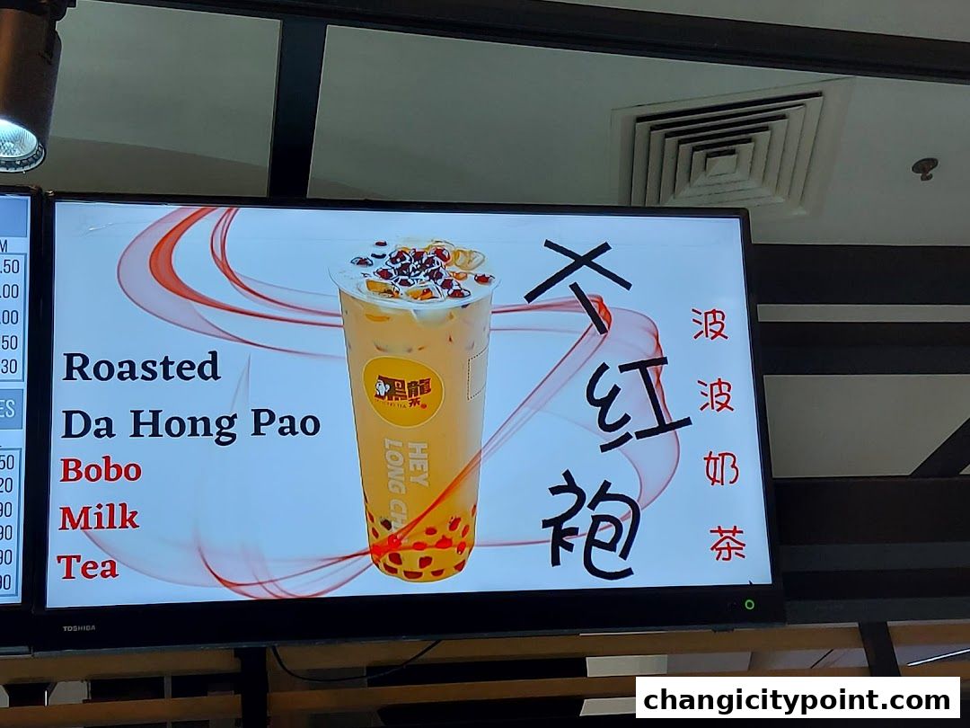 A digital menu board displaying a 'Roasted Da Hong Pao Bobo Milk Tea' with Chinese characters.