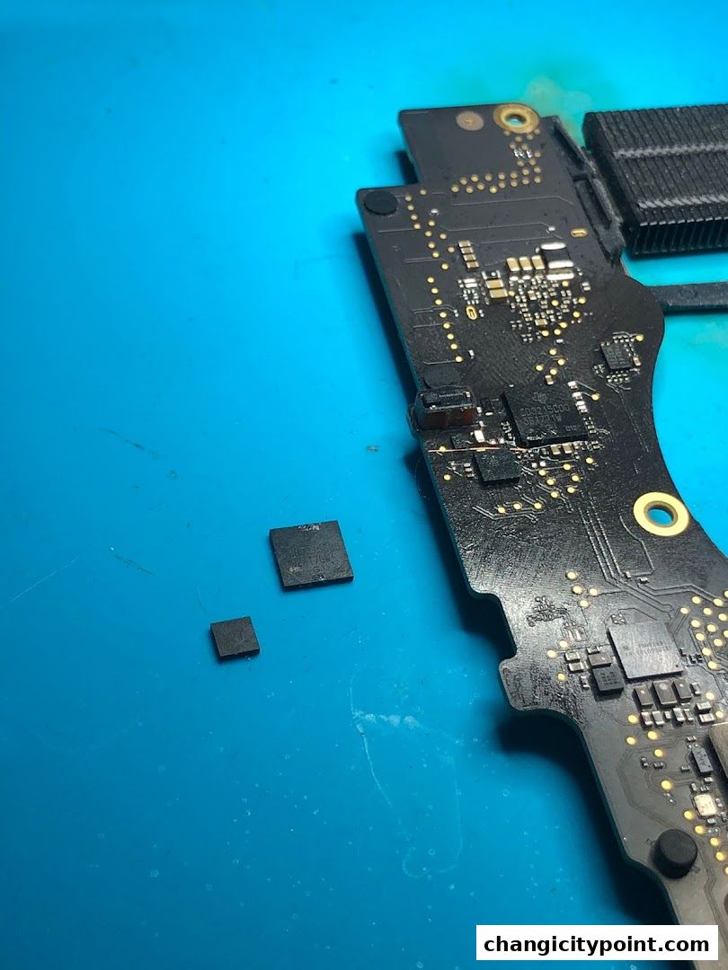 Close-up of electronic components and a circuit board on a blue surface.