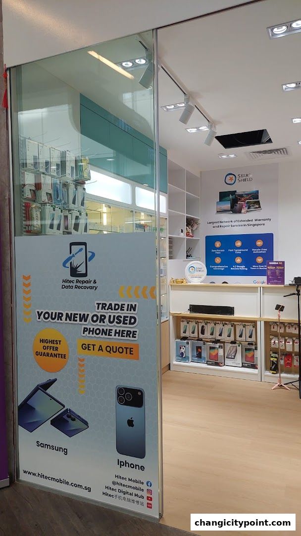 Entrance to Hitec Digital Hub, a phone repair and trade-in shop, showcasing phone models and services.