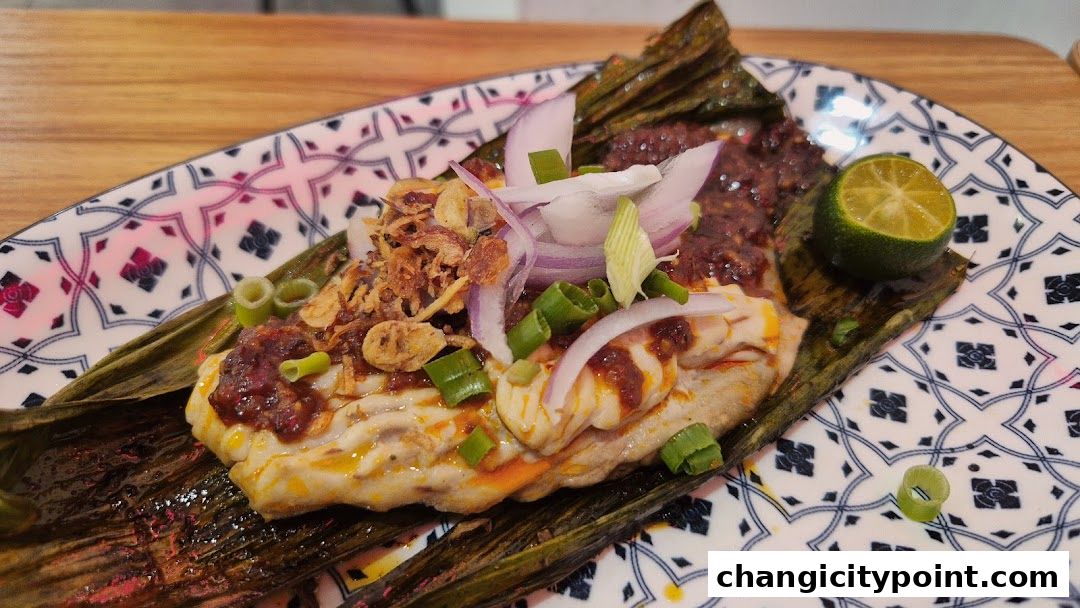 A delicious prawn dish served on a banana leaf with lime and onions.