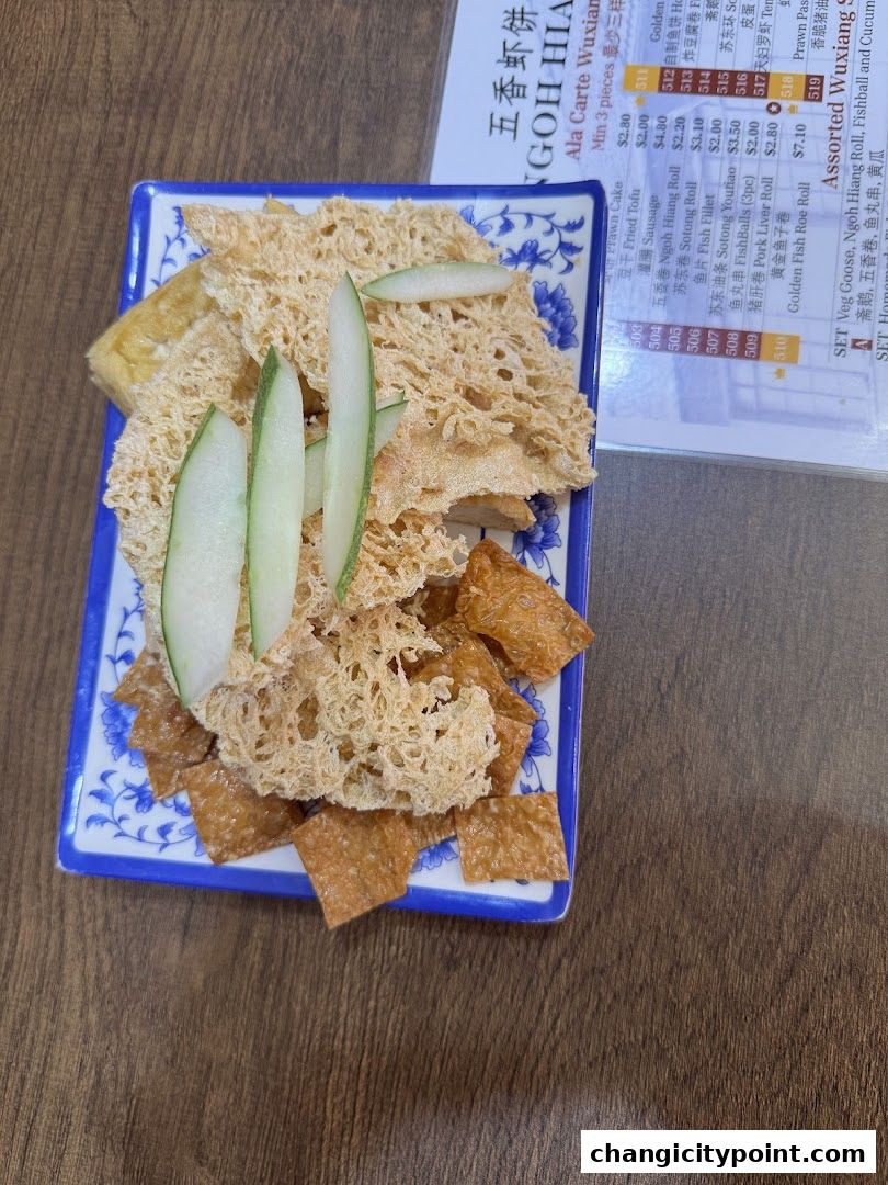 A plate of fried snacks with cucumber slices and a menu in the background.