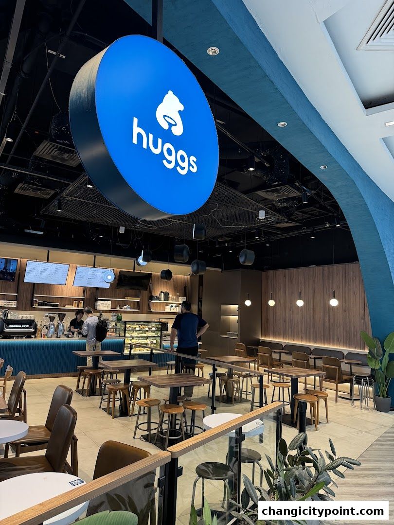 Interior view of Huggs Coffee shop with seating, counter, and signage.