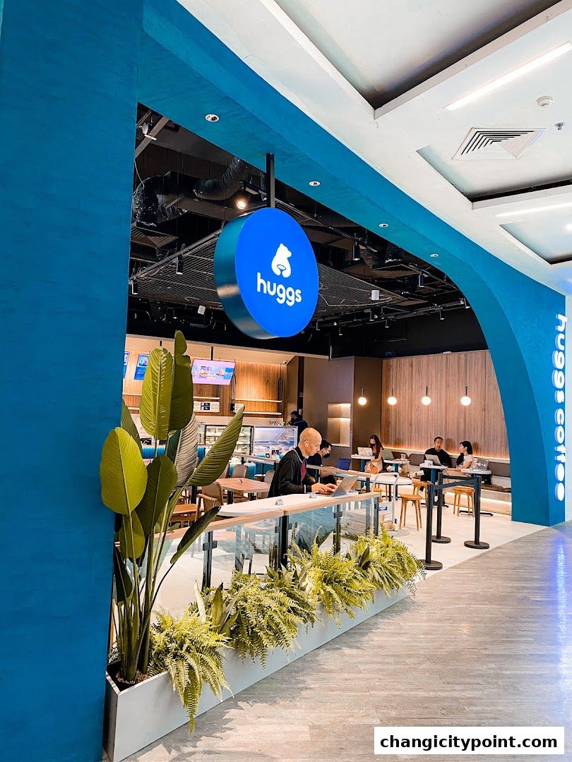 Modern Huggs Coffee shop interior with customers working and dining.