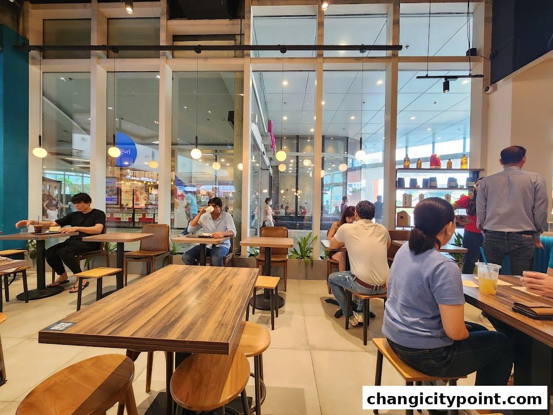 Interior view of Huggs Coffee shop with customers seated at tables and enjoying their drinks.