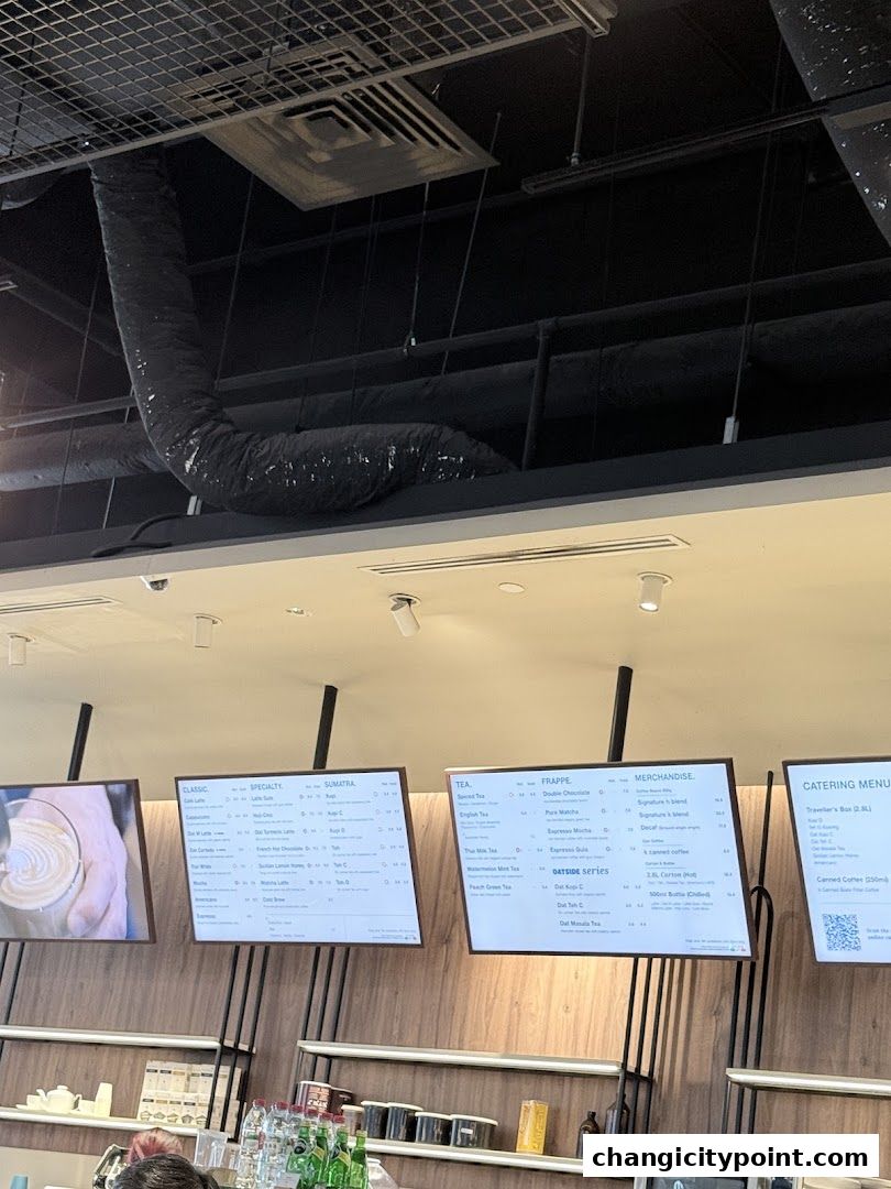 Digital menus displaying coffee, tea, frappe, merchandise, and catering options.