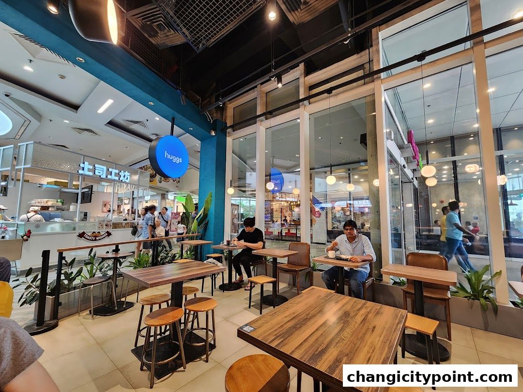 Interior view of Huggs Coffee shop with seating areas and customers.