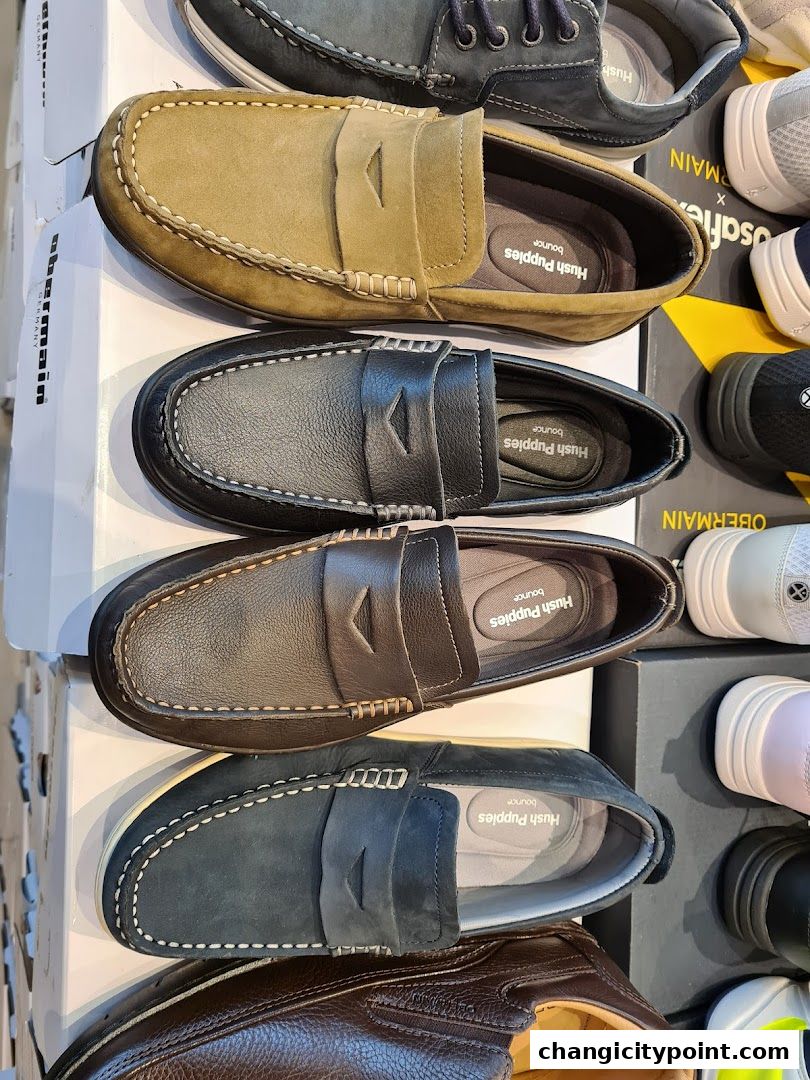 A display of various Hush Puppies loafers and casual shoes in different colors and materials.