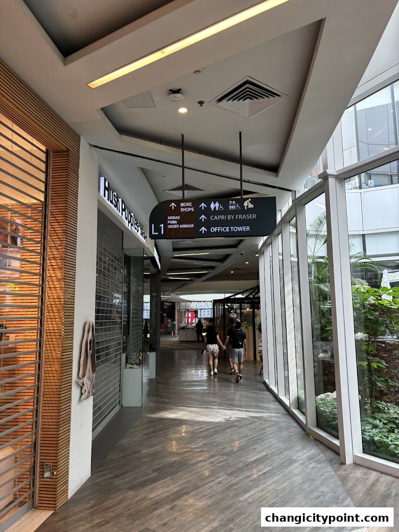 A shopping mall corridor with Hush Puppies store and directional signage.