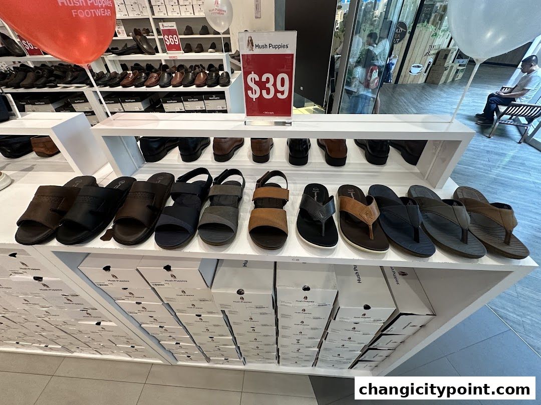 A display of Hush Puppies footwear, featuring sandals and shoes, with price tags visible.