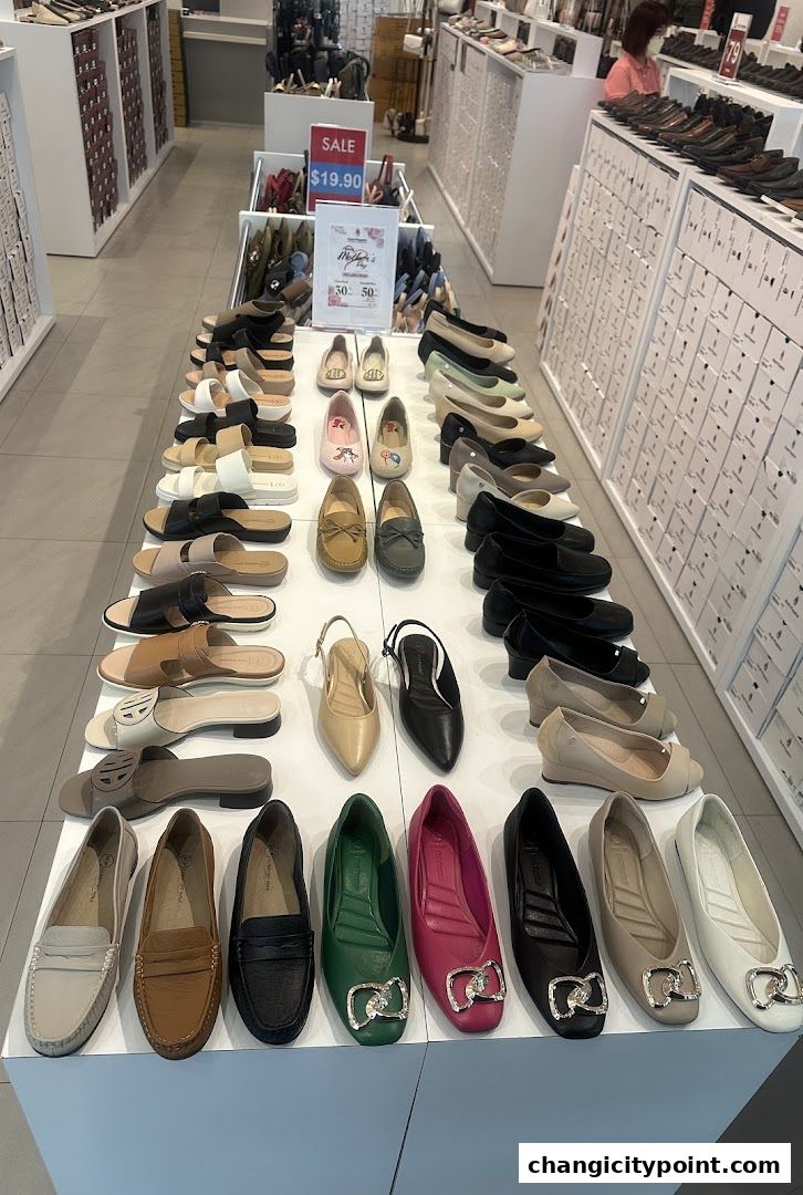 A wide selection of women's shoes displayed on shelves and tables inside a retail store.
