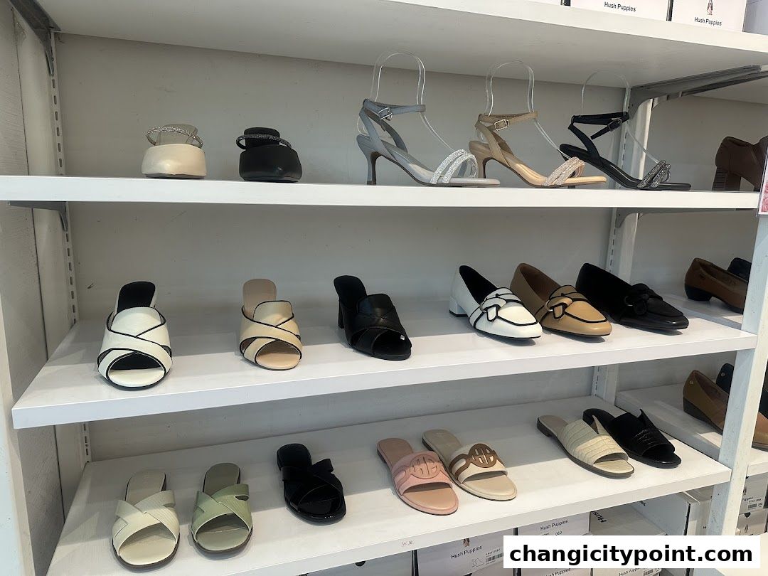 A display of various Hush Puppies women's shoes on shelves.