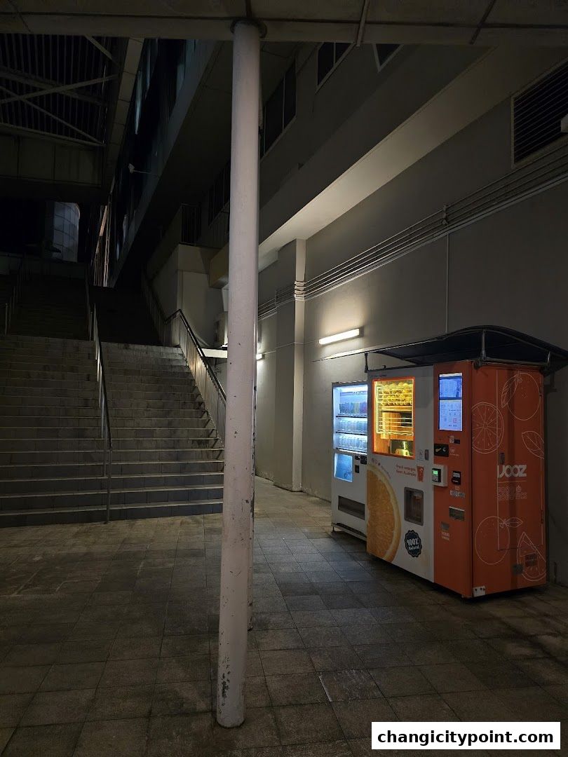 An iJooz pure fruit juice vending machine is located next to a set of stairs.