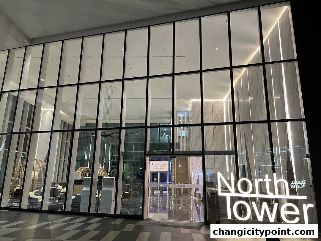 Modern glass-fronted building entrance with illuminated 'North Tower' signage.