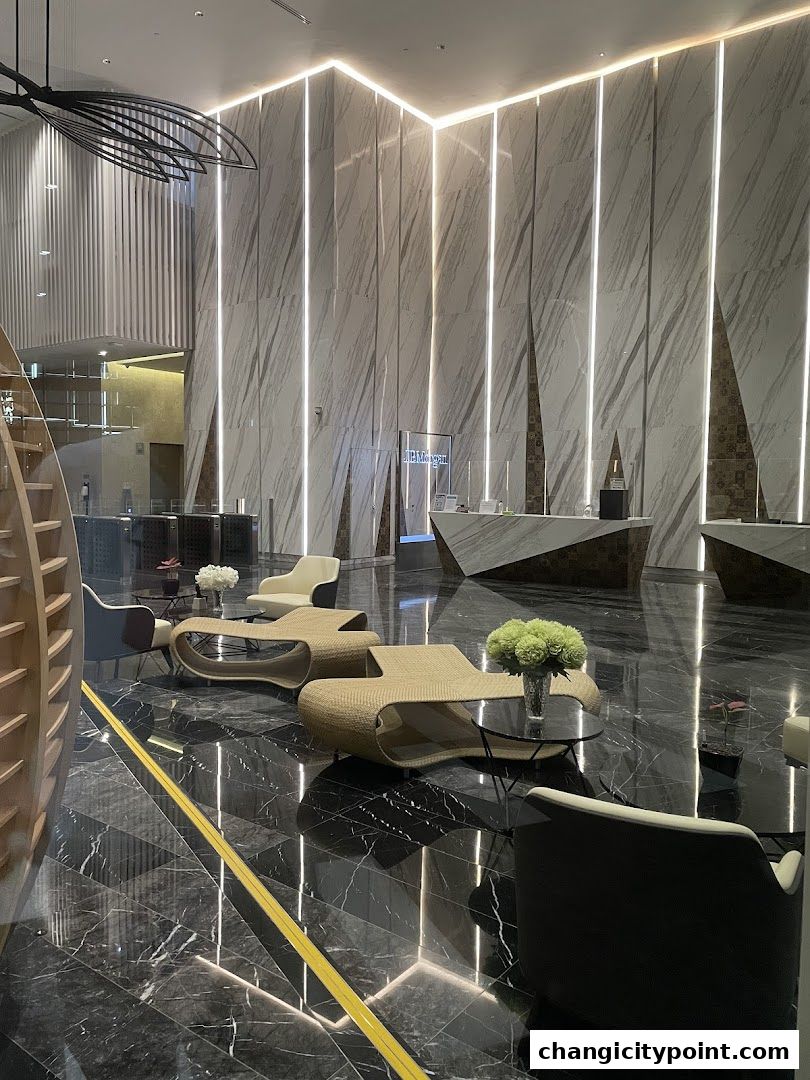 Modern lobby with marble walls, sleek furniture, and ambient lighting.