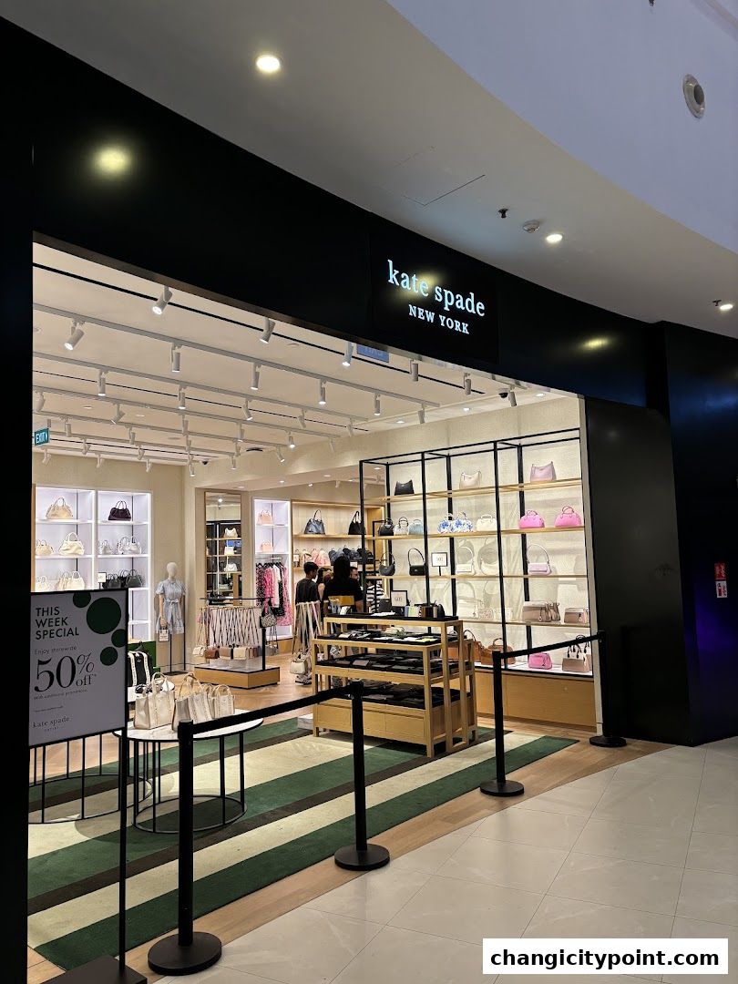 The entrance of a Kate Spade New York store showcasing handbags and accessories with a special offer sign.