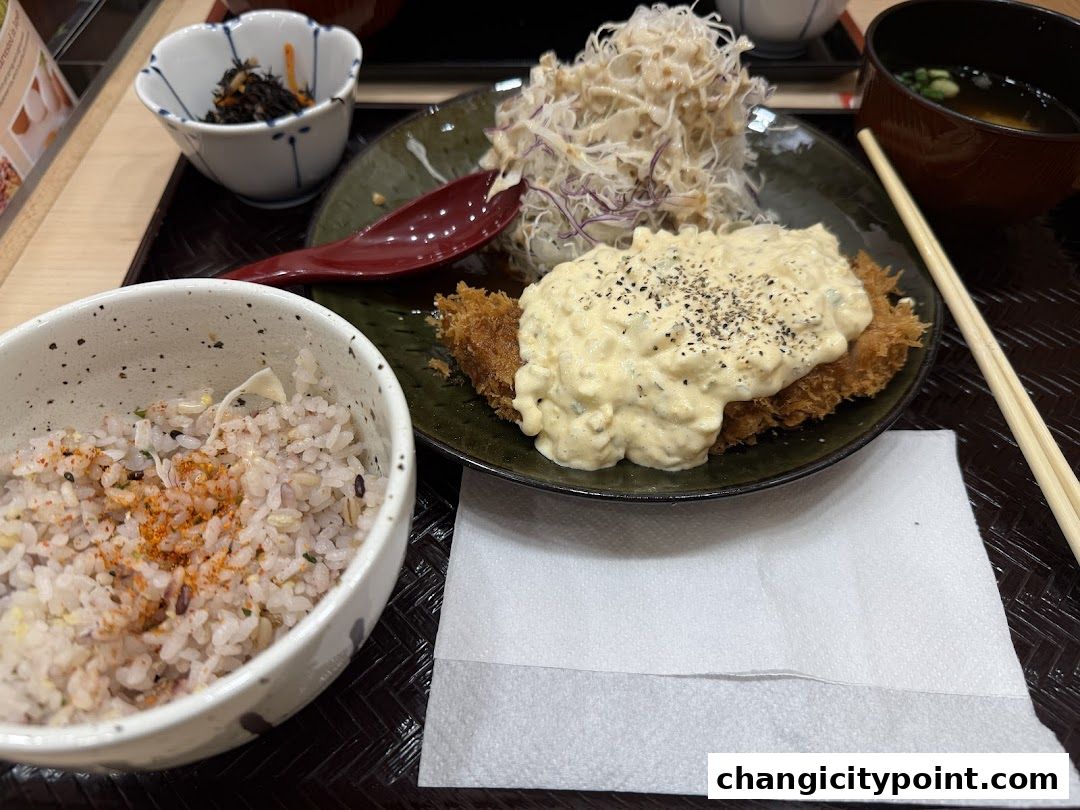 A delicious katsu dish with rice, soup, and side dishes.