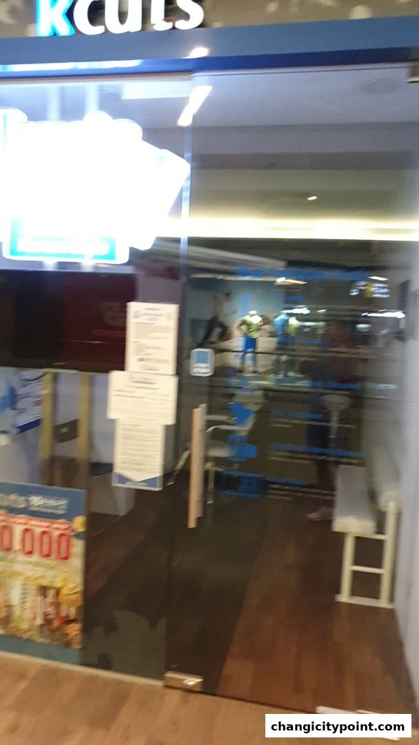 The entrance of a Kcuts hair salon with glass doors and signage.