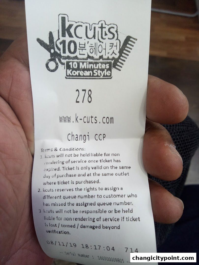 A queue ticket from kcuts Changi City Point with a queue number and terms.