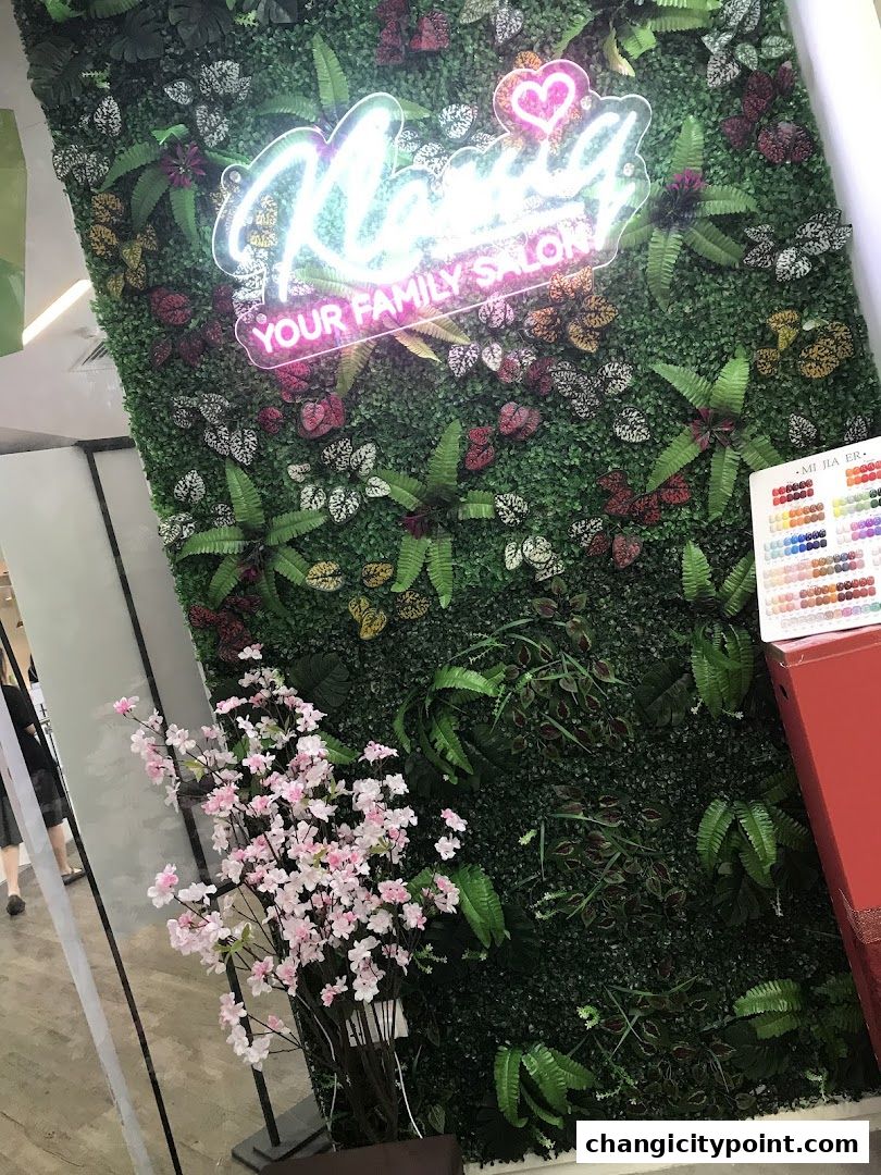 Klassiq Family Salon storefront with a neon sign and a vertical garden wall.