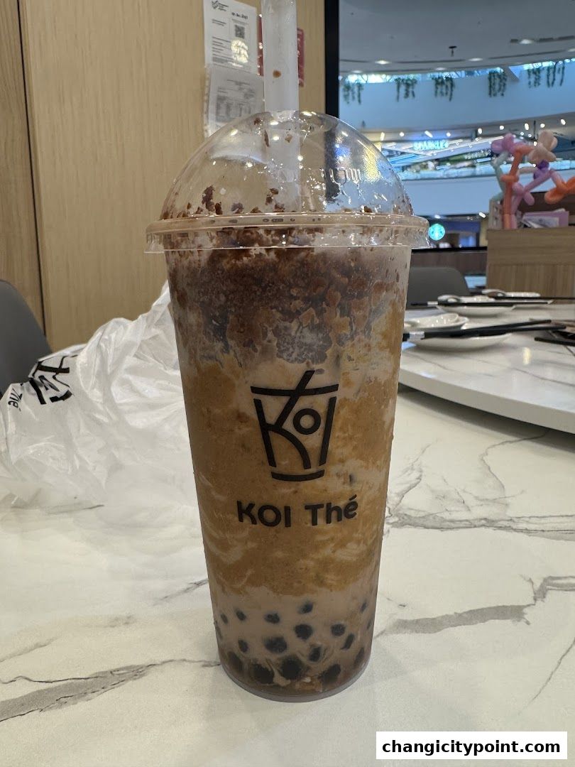 A close-up of a KOI Thé bubble tea drink with tapioca pearls.