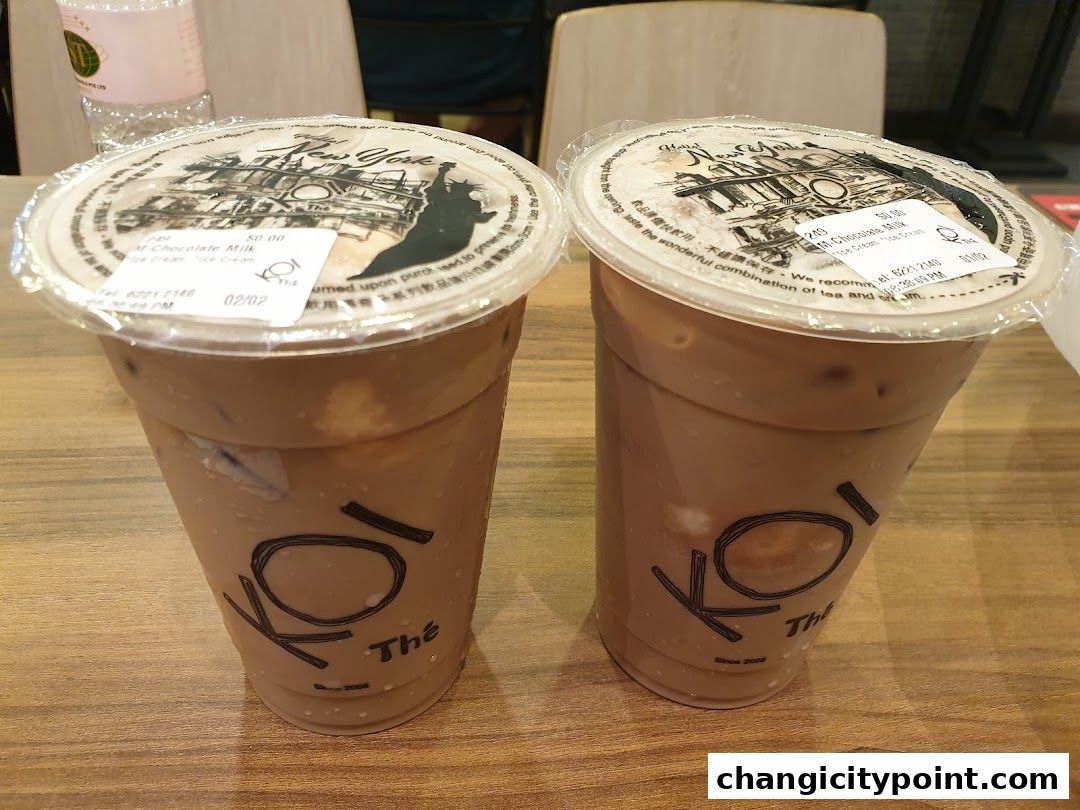Two KOI The bubble tea drinks with chocolate milk flavor on a wooden table.