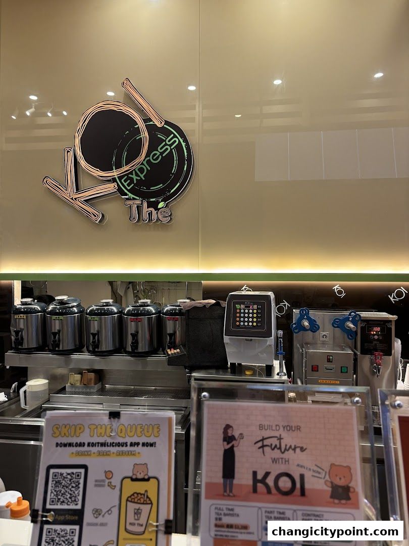 The interior of a KOI Express bubble tea shop with equipment and promotional signs.