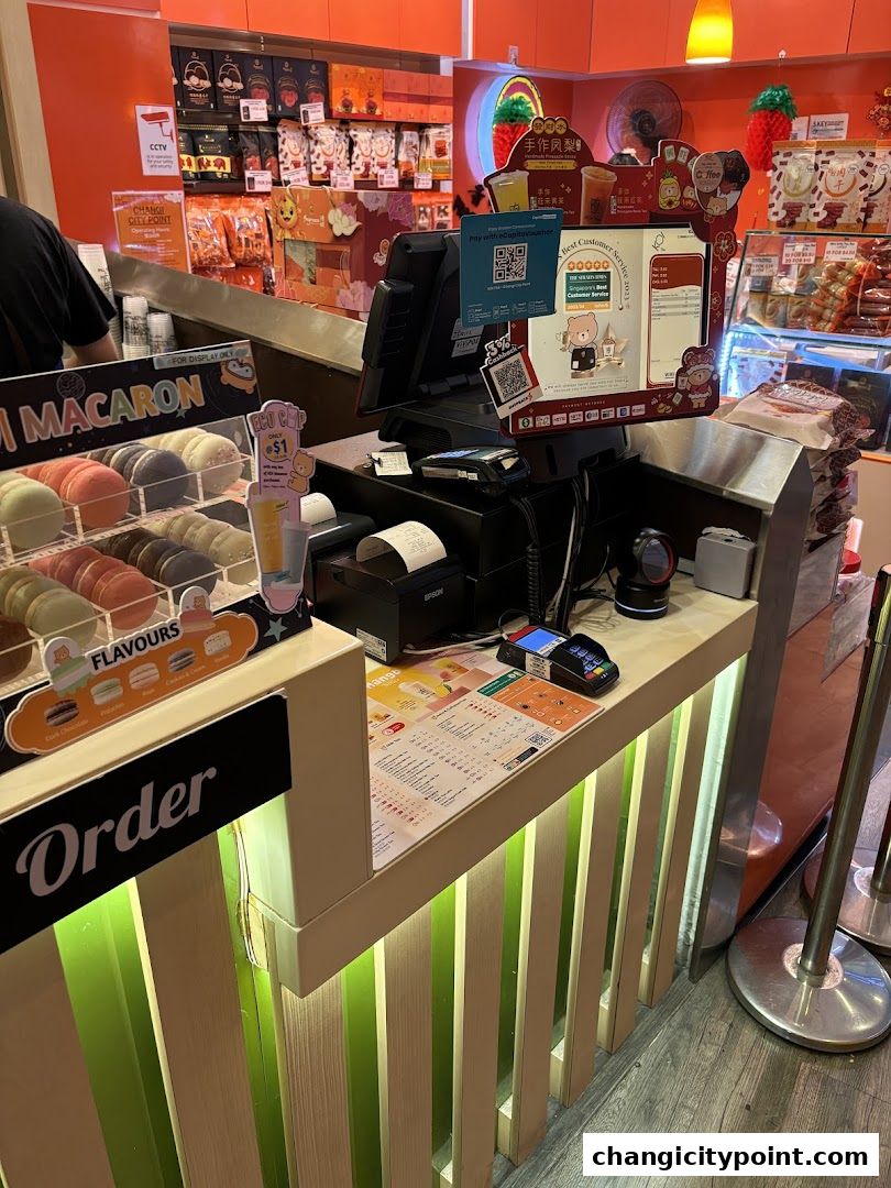 A counter at KOI Express with macarons, drinks, and payment terminals.