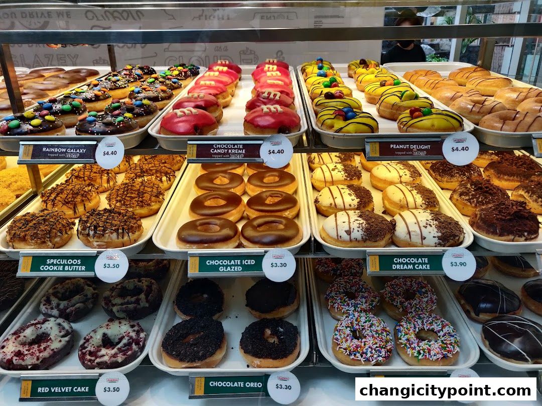 A display case filled with a variety of colorful and decadent donuts from Krispy Kreme.