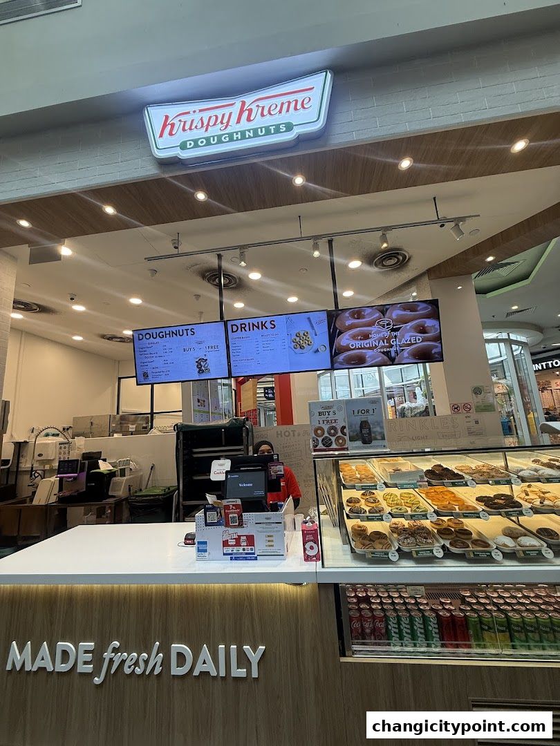 Krispy Kreme shop front with a display of doughnuts and a menu board.