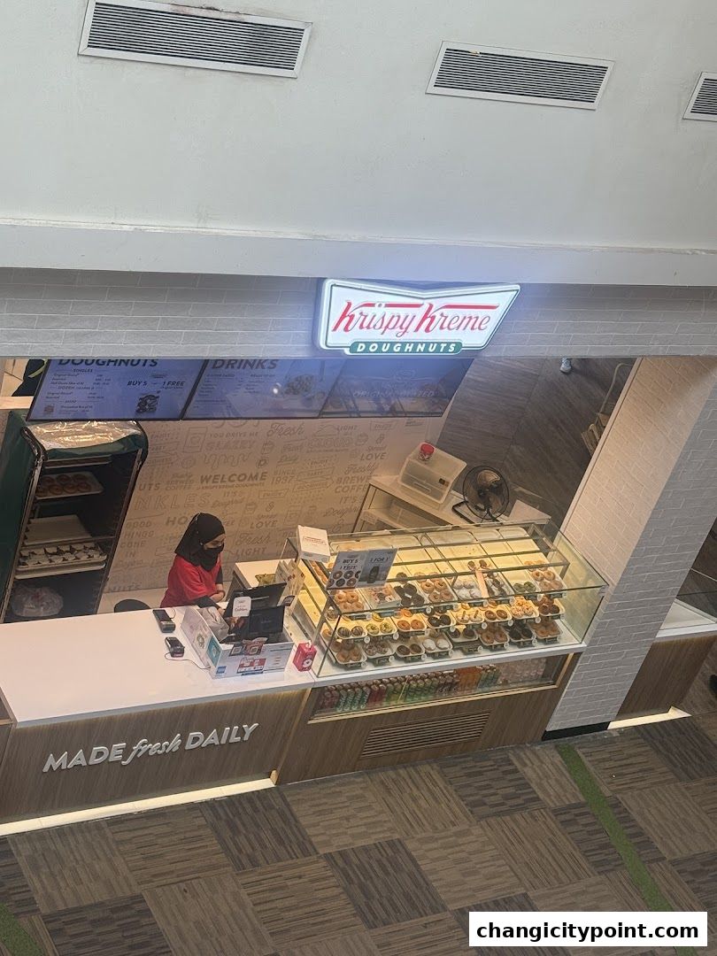 A Krispy Kreme doughnut shop counter with a display of doughnuts and a menu board.