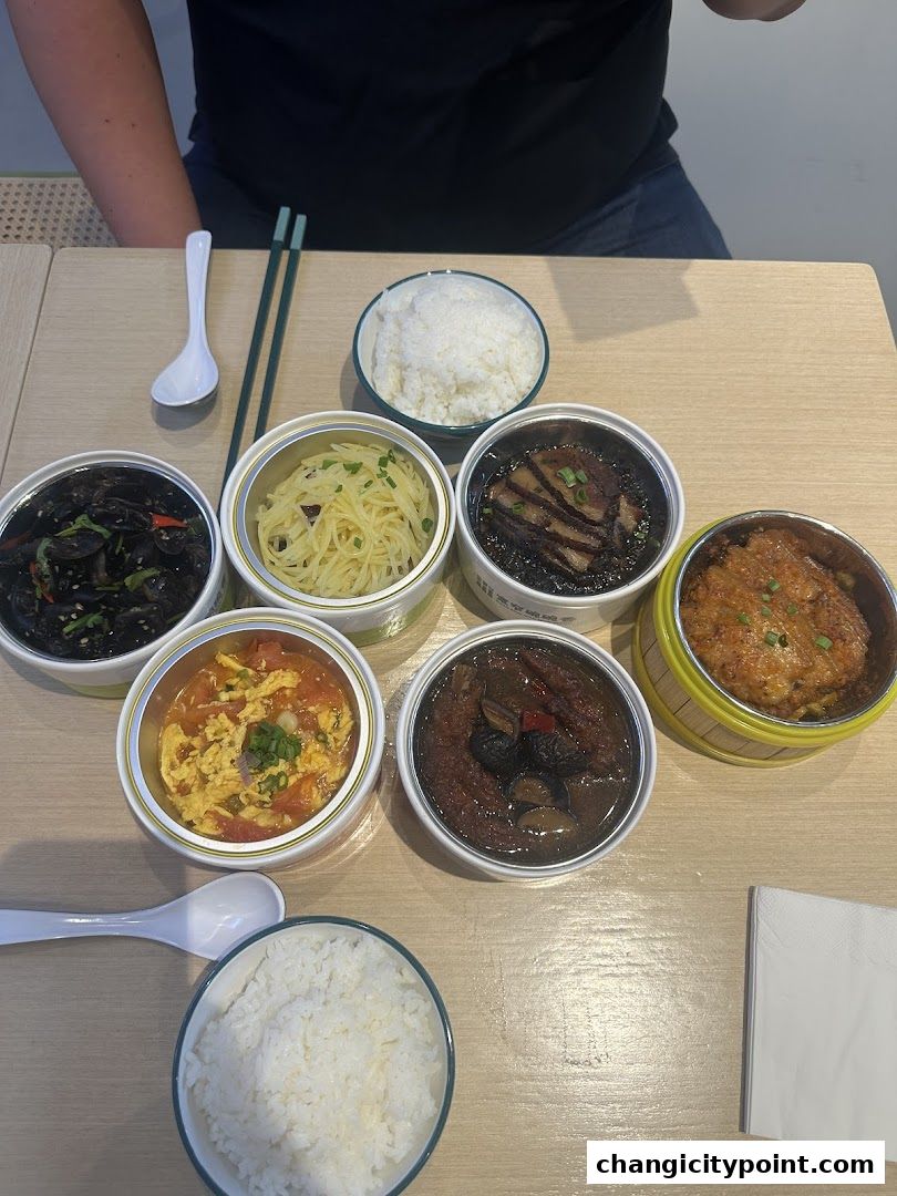 A table laden with various Chinese dishes and rice, ready for a meal.