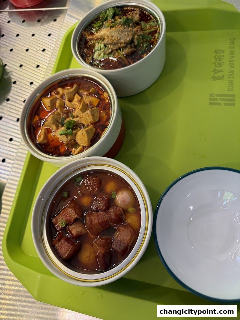 Three bowls of delicious Chinese food served on a green tray.