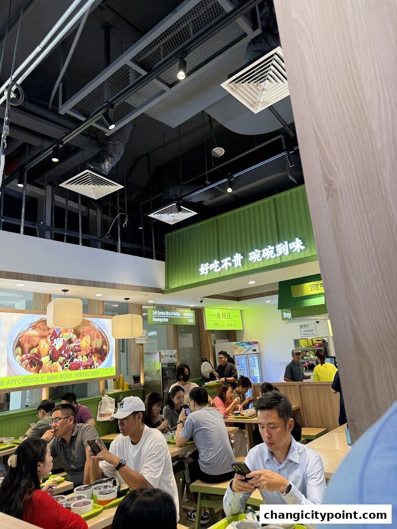 People dining at a casual restaurant with a large food display and signage.