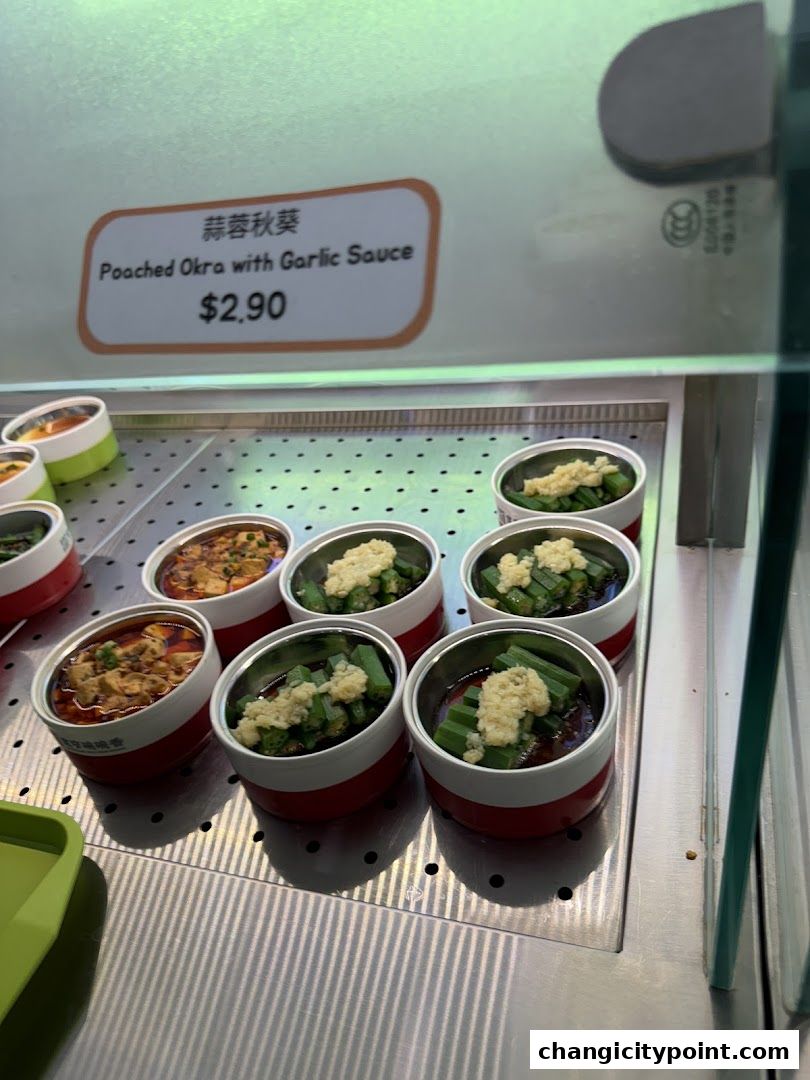 A display of small bowls of poached okra with garlic sauce, priced at $2.90.