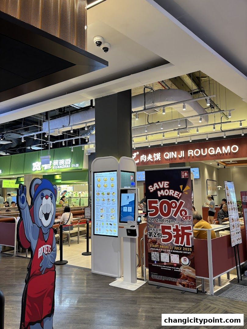 A food stall with a digital menu, a mascot, and a promotional banner.