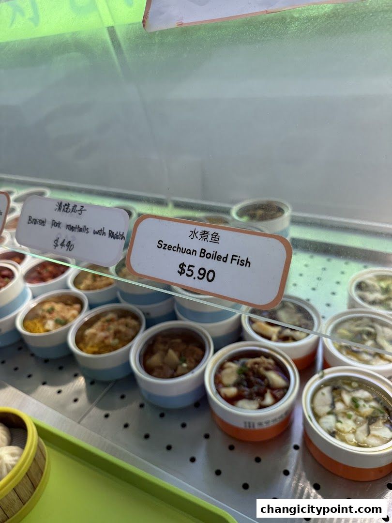 A display of pre-portioned Chinese dishes, including Szechuan Boiled Fish and Braised Pork Meatballs.