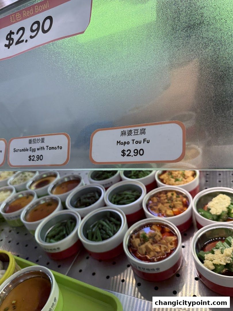 A display of small, pre-portioned dishes with labels and prices.
