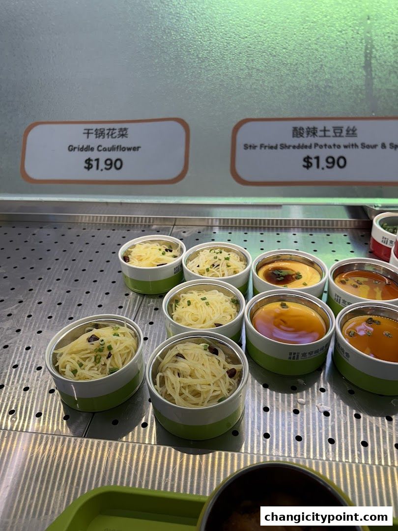 Individual servings of prepared dishes displayed in small containers with labels.