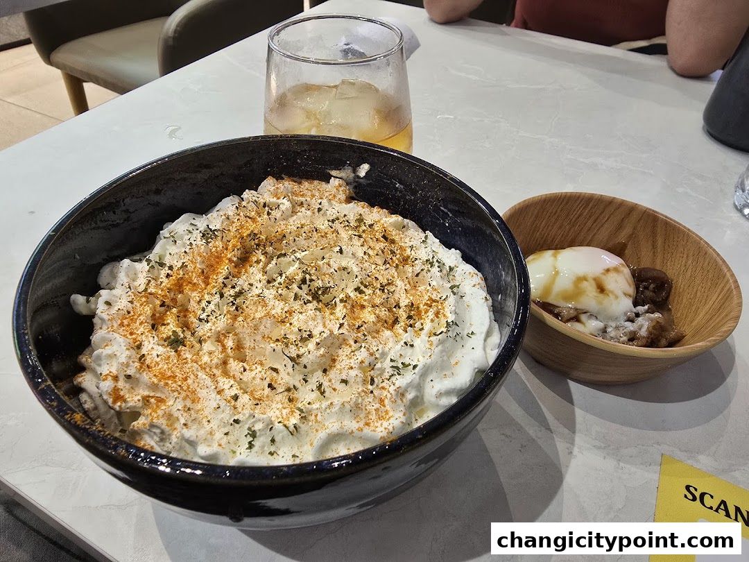 A close-up of a creamy dessert with spices and a side dish with an egg.