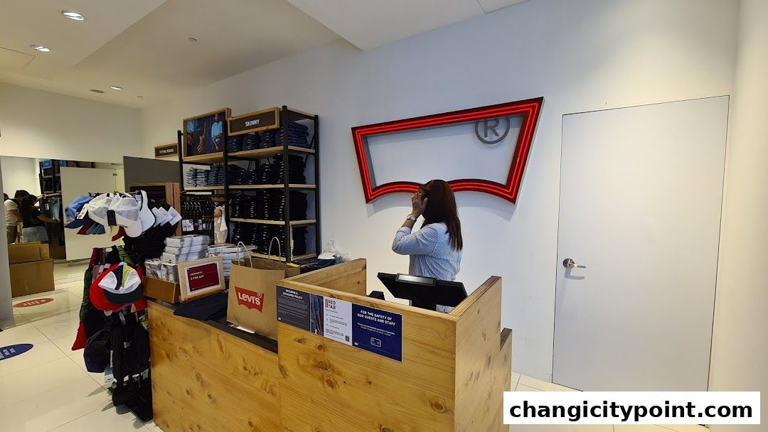 Interior view of a Levi's Outlet store with jeans, caps, and a cashier counter.