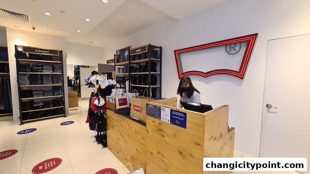 Interior of a Levi's store with jeans displayed and a cashier at the counter.